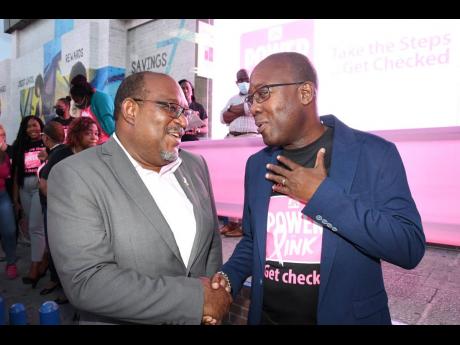 Michael Leslie (left), acting executive director of the Jamaica Cancer Society, was the picture of delight as he greeted Hugh Reid, general manager of JN Life Insurance Limited at the event.