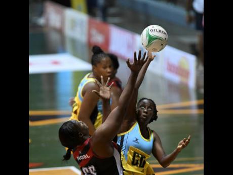 Trinidad and Tobago’s Afeisha Noel (left) competes for the ball with St Lucia’s Kiana Nelson during their  Americas Netball World Cup qualifier at the National Indoor Sports Centre last night.