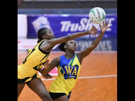 Jamaica's Tafiya Hunter (left) challenges St Vincent and the Grenadines' Ruthan Williams during their opening-day Americas Netball World Cup Qualification fixture at the National Indoor Sports Centre earlier this evening.  