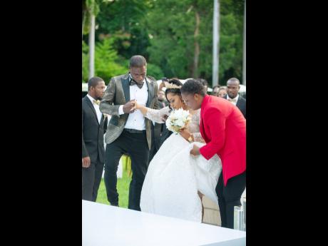 The beautiful bride is escorted up the aisle by her handsome groom (left), with the assistance of Tashana Brown Johnston of Blush and Cherish Events.