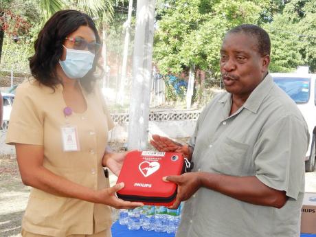 Robert Montague, member of parliament for Western St Mary, hands over a defibrillator to Public Health Nurse Odette Wilson at the Oracabessa Health Clinic on Thursday. 