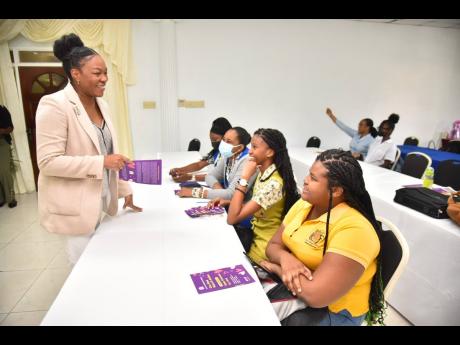 Jamaica Constabulary Force Cyber Safety Unit representative, Corporal Samantha Ewan (left), speaks with student teachers from Shortwood Teachers’ College in Kingston (from third left) Janelle Notice, Ashley Isaacs and Chevonese Wallace, during the openin