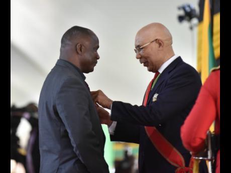 Governor General Sir Patrick Allen (right) bestows Gleaner photojournalist Ian Allen with the Badge of Honour for Meritorious Services for his contribution to journalism.