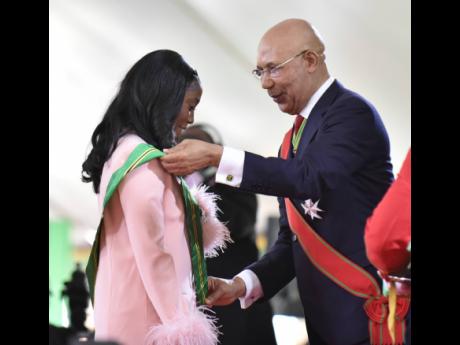 Governor General Sir Patrick Allen bestows Shelly-Ann Fraser-Pryce with the Order of Jamaica for her achievements in the sport of track and field during the Ceremony of Investiture and Presentation of National Honours and Awards at King’s House in St And