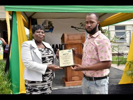Jermey Atkinson (right) accepts his award for bravery from Marvalyn Pitter, chief executive officer, Westmoreland Municipal Corporation (WMC), at the Jamaica Cultural Development Commission and the WMC Heroes Day Salute and Awards Ceremony held in Norman S