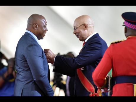 Photojournalist Rudolph Brown (left) receiving the Badge of Honour for Meritorious Service for his contribution to journalism from Governor General Sir Patrick Allen at the National Awards Ceremony at King’s House on Monday. Photo by Kenyon Hemans