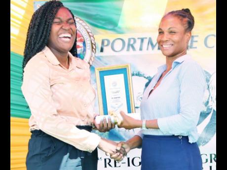 Recipient of the Youth Development Award at Monday’s Portmore Heritage, Civic and Awards Ceremony, Shennika Keane, is clearly delighted as she accepts the award and citation from Ishiwawa Hope of the Social Development Commission.