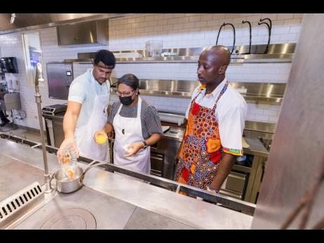 Mother-son cooking duo, Josef (left) and Shernette Crichton, general manager of Half Moon, create the sauce for their candied yams as Chef Munye watches closely.