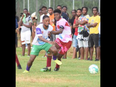 William Knibb High’s Mark Lewis (left) battles with Spot Valley High’s Javane Clarke during an ISSA/Digicel daCosta Cup match at the William Knibb Sports Complex on Saturday, September 17.  William Knibb won 3-0.