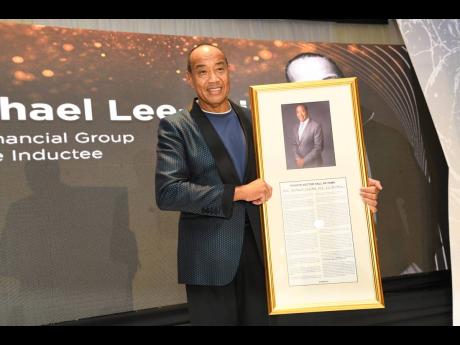 Jamaican billionaire businessman Michael Lee-Chin shows off his citation as he was inducted into the Private Sector Organisation of Jamaica Hall of Fame during a glittering banquet at The Jamaica Pegasus hotel in New Kingston on Thursday.