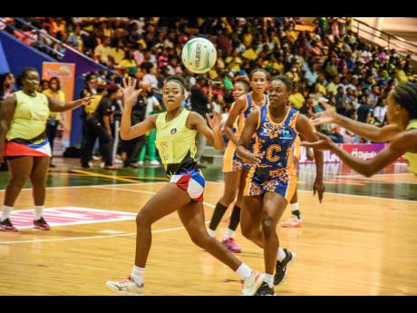 
Jonelly Encarnacion (left), playing centre for Antigua and Barbuda, catches a pass as Tonisha Rock-Yaw of Barbados looks on during final-day action from the Americas Netball World Cup qualifiers at the National Indoor Sports Centre yesterday.