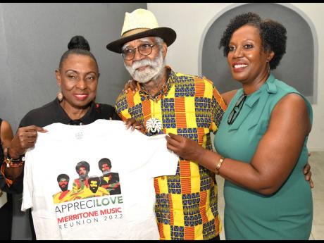 A MERRI GIFT :  Minister of Culture Olivia Grange (left), is delighted with a gift of a Merritone Music T-shirt presented to her by Monte Blake,  one of the founder’s  of Merritone and his daughter Monique,  managing director.  The occasion was the launc