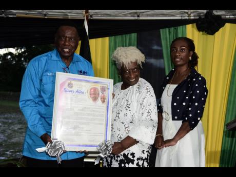 Councillor Leeroy Williams (left), Mayor of Montego Bay, presenting a citation to the Allen family at a road renaming ceremony last Thursday. Accepting the citation are Veronica Allen (centre), widow, and daughter Nicole Allen, attorney-at-law. Pitfour Dri