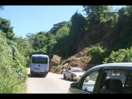 Motorists negotiate the one lane created after a major land slippage in Lucea, Hanover over the weekend.