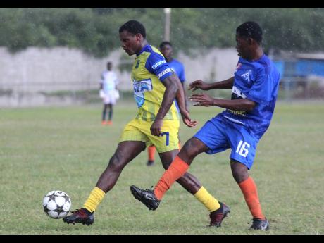 Clarendon College captain Malachi Douglas marches away from St Mary Technical player Kevin Marsh during their ISSA/ daCosta Cup second-leg second-round encounter at Foga Road yesterday.