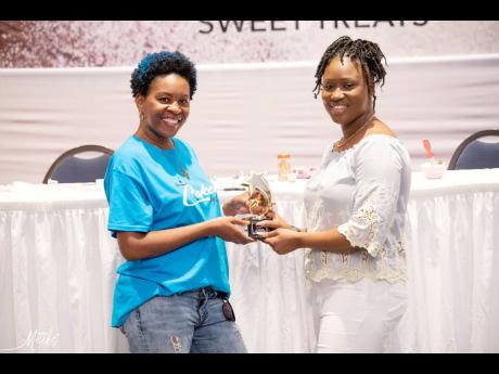 No stranger to the Sweetart Bake Expo, Laqueata Donaldson (left) of Cakes by Queata won first place in the travel category, as well as the people’s choice award for her Air Jamaica cake. Shonick McFarlane presents her a trophy for her achievement.