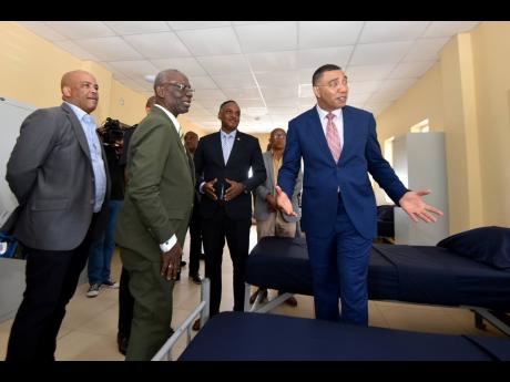 Foreground, from left: Morant Bay Mayor Michael Hue; Desmond McKenzie, minister of local government and rural development; Omar Sweeney, managing director of the Jamaica Social Investment Fund; and Prime Minister Andrew Holness tour the Yallahs Fire Statio