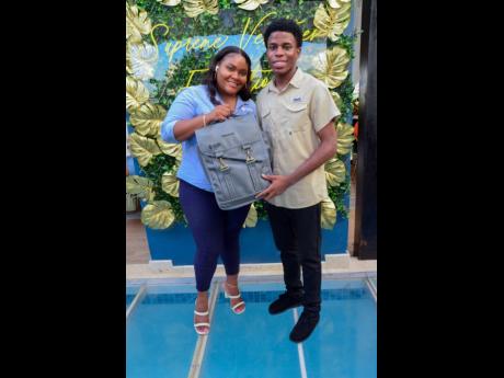 Senior Marketing Manager of Supreme Ventures Limited, Kajay Rowe (left), presented Caribbean Maritime University student Kimani Howard, with a token of courtesy from the SVL Foundation.