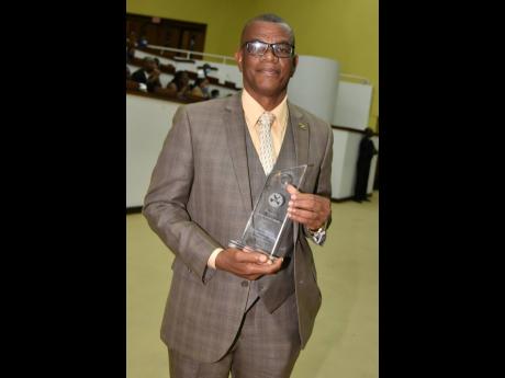 Albert Brown shows off his award for 40 years of stellar service with the Department of Correctional Services. The 61-year-old was acknowledged during the DCS Staff Awards Ceremony on Thursday.