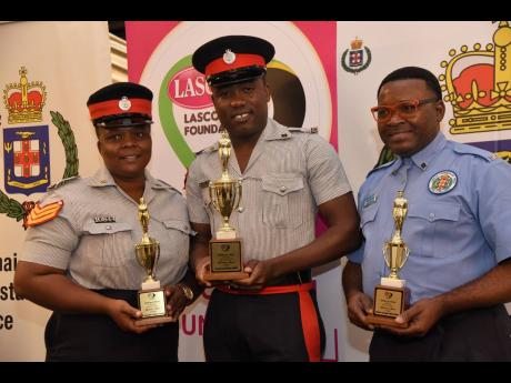 Corporal Rohan Smith (centre) shows off his trophy after winning the LASCO/Jamaica Constabulary Force (JCF) Police Officer of the Year Award. He is joined by first runner-up Alsian Clayton (left) and second runner-up Alfred Palmer. The award ceremony was h