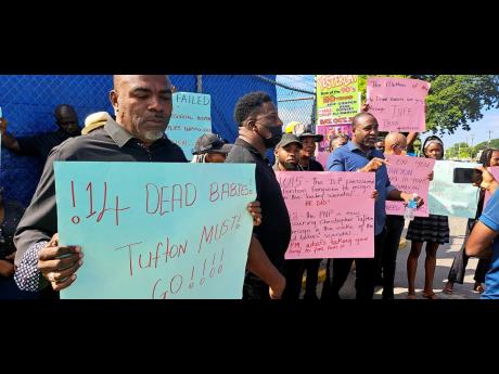 Waterford division Councillor Fenley Douglas (left), Treadways division Councillor Sidney Rose (centre), and PNP General Secretary Dr Dayton Campbell participate in a protest outside the Spanish Town Hospital on Monday. The demonstrators called for the res