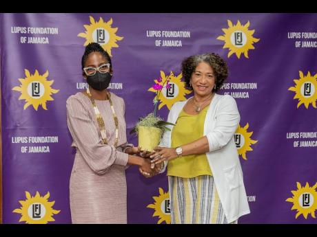 Dr Taneisha McGhie-Phillips (left), Lupus Foundation of Jamaica volunteer, shares a photo with Dr Karen Carpenter who presented at the symposium.