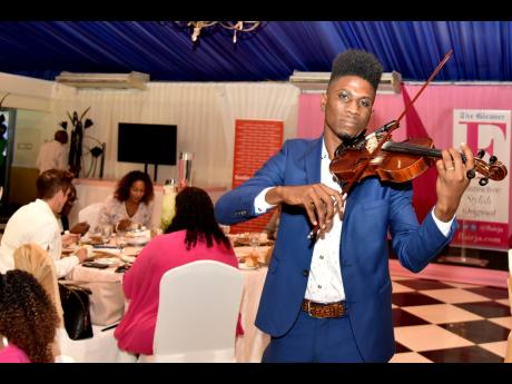 Violinist Kamoy Gordon performing during the Live with Flair luncheon celebrating breast cancer survivors held at the Tera Nova Hotel in St Andrew last Monday. 