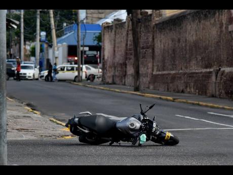 A police service motorcycle lies at the intersection of East and East Queen streets where a cop was shot and injured adjacent to the Central Police Station. He has been hospitalised but his injuries are not believed to be life-threatening.