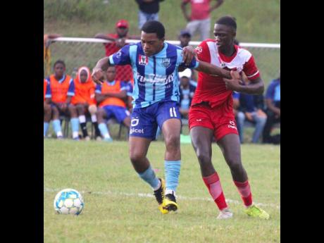 The Manning’s School midfielder, Rushawn Graham )left), tussles with Glenmuir High School's Ja-son Whyte during their ISSA daCosta Cup round-of-16 clash at Glenmuir High yesterday.