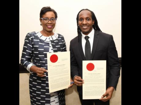 Ambassador Sheila Sealy Monteith, permanent secretary in the Ministry of Foreign Affairs and Foreign Trade, and Alando Terrelonge, minister of state in the Ministry of Culture, Gender, Entertainment and Sport, display their instruments shortly after being 