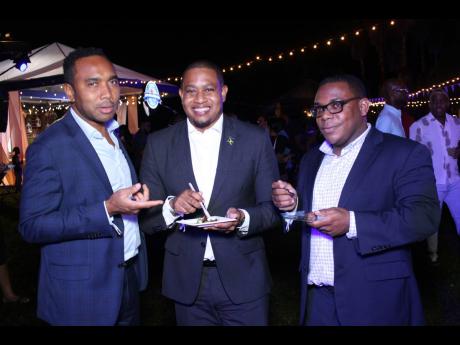 Floyd Green (centre), minister without portfolio in the Office of the Prime Minister, is seen enjoying the Pork Palooza festivities. He is joined in a photo op by Bobby Honeyghan, general manager of the Urban Development Corporation Jamaica (left) and Chri