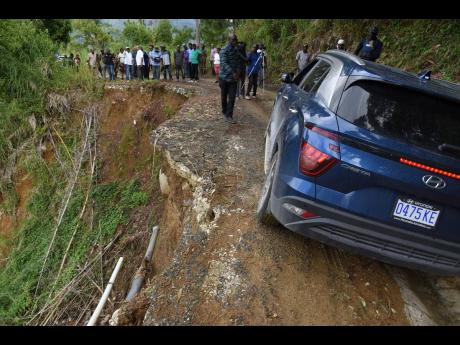 A motorist drives perilously close to the edge of an eroding roadway in Mount Vernon Gap, St Thomas Western, on Wednesday.