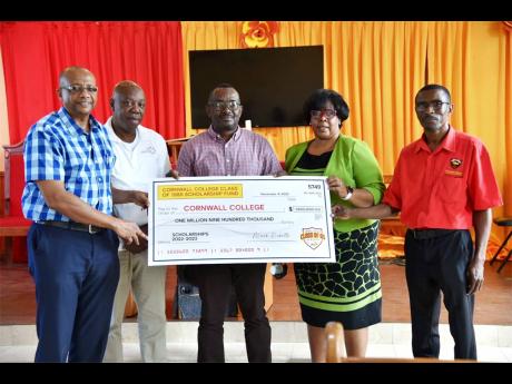 Michael Ellis (centre), principal of Cornwall College, and Dr Michelle Pinnock (second right), region four director, Ministry of Education and Youth, accept a symbolic cheque for $1.9 million in scholarship funds to go towards the academic pursuits of 42 s