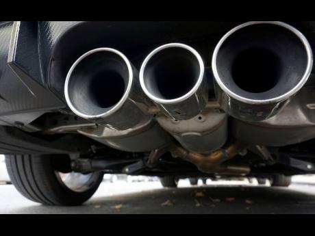 FILE  - Exhaust pipes of a car are pictured in Berlin, Germany, Tuesday, Oct. 9, 2018. The European Parliament and EU member countries have reached a deal to ban the sale of new gasoline and diesel cars and vans by 2035. EU negotiators sealed on Thursday, 