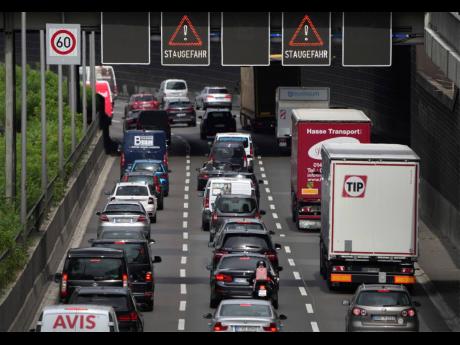 FILE -- Cars and trucks drive on the A100 highway in Berlin, Germany, Wednesday, June 29, 2022. Officials said Monday that Germany is postponing politically sensitive decisions on reducing greenhouse gas emissions in the transport sector until 2023, amid s