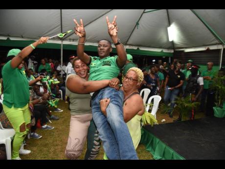 Leroy Dunn, councillor caretaker for the Guy’s Hill division, is hoisted by Jamaica Labour Party supporters during the St Catherine North Eastern constituency conference on Sunday. The party staged several council meetings across the island, including in