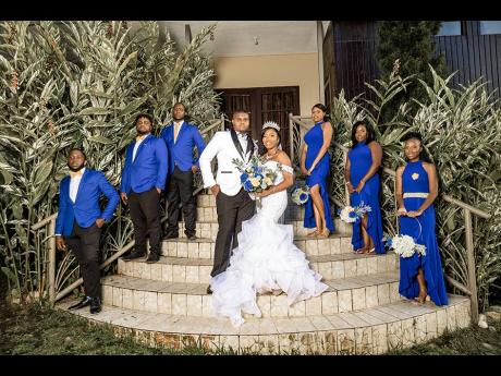 The regal groom and bride are accompanied by their elegant bridal party in royal blue. 