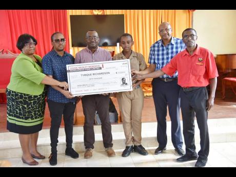 Huntley Medley (right), former chairman of the Cornwall College Class of ‘85 Scholarship Fund and managing director of the Odane Medley Memorial Fund Limited, presents a cheque valued at $50,000 to Tyrique Richardson (third right), a first-form student a