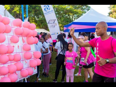 Perfect aim! Richard Hutchinson sets up the dart just right with the hopes of winning a prize at EdgeChem’s booth at the ICWI/Jamaica Reach to Recovery Pink Run. 