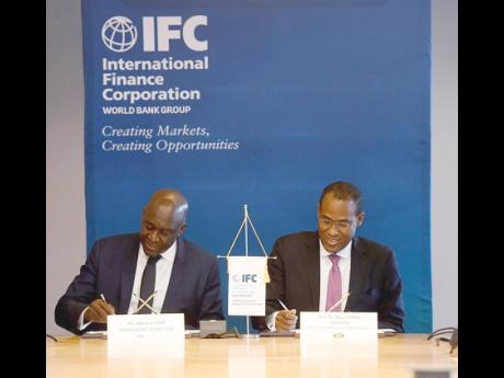 Finance Minister Dr Nigel Clarke (right) and IFC Managing Director Makhtar Diop sign the FASA for the development of the US$800-million North Coast Highway public-private partnership project in Washington, DC, on October 13.