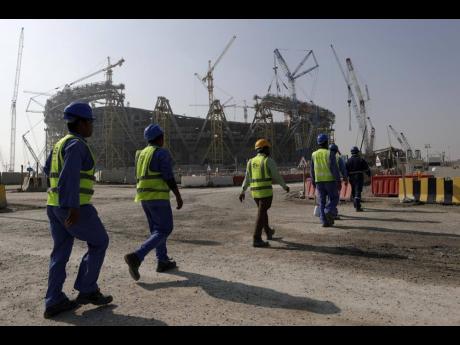 In this file photo, labourers walk to the Lusail Stadium, one of the World Cup stadiums, in Lusail, Qatar, in December 2019.  AP
