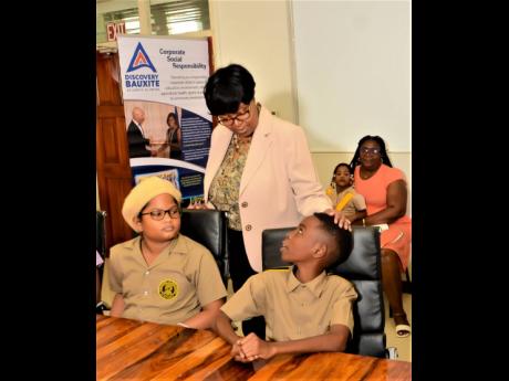 Discovery Bauxite’s Human Resource Manager Nordia Tracey has encouraging words for company scholarship winners, York Castle High’s David Samaroo (left) and Teves Gordon, who are among the 150 students from Discovery’s operating areas in St Ann who wi