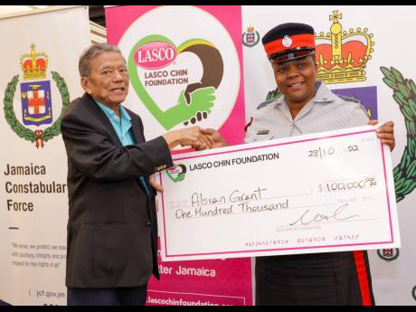 Lascelles Chin, founder and executive chairman of LASCO Affiliated Companies, proudly presents Chairman’s Awardee Woman Sergeant Alsian Clayton with her cash prize valued at $100,000 at the LASCO/Jamaica Constabulary Force Saluting Our Heroes and Chairma