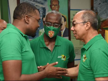 Jamaica Labour Party General Secretary Dr Horace Chang (right) huddles with Conference Chairman Desmond McKenzie (centre) and Public Relations Officer Robert Morgan during Thursday’s press conference outlining the rules for the party’s upcoming annual 
