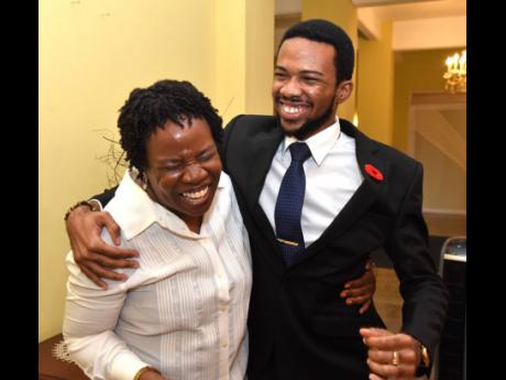 David Salmon, the 2023 Rhodes Scholar, gets a hug from his mom, Donnahae Rhoden-Salmon, shortly after Governor General Sir Patrick Allen made the announcement at King's House on Thursday.
