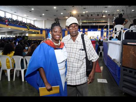 Celine Lobban (left) celebrates her graduation from The University of Technology, Jamaica, with her father, Evon Lobban, at the ceremony for the presentation of the Class of 2022 graduates at the National Arena on Friday.