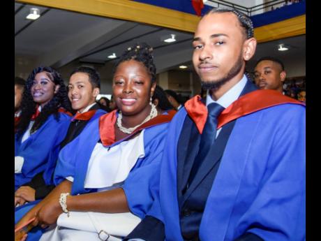 From right: School of Computing and Information Technology graduates Alexander McIntosh, Celine Lobban, Michael Levy and Barri-Ann Lawrence pose for a photo during their graduation ceremony at the National Arena on Friday.