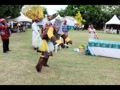 A masquerader performs in similar fashion to Jamaican Jonkonnu dancers.