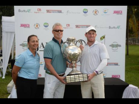 Jamaica Golf Association President Jodi Munn-Barrow (left) and Scott Summy (centre) of Aqua Bay Resorts hand over a trophy to Patrick Cover, winner of the 55th Jamaica Open Golf Classic at the Tryall Golf Course in Hanover yesterday.