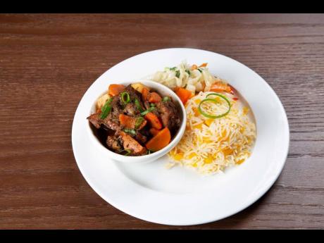 The brown stewed chicken dish is served up with tasty pumpkin rice and a tossed salad that  makes an amazing meal for lunch or dinner.